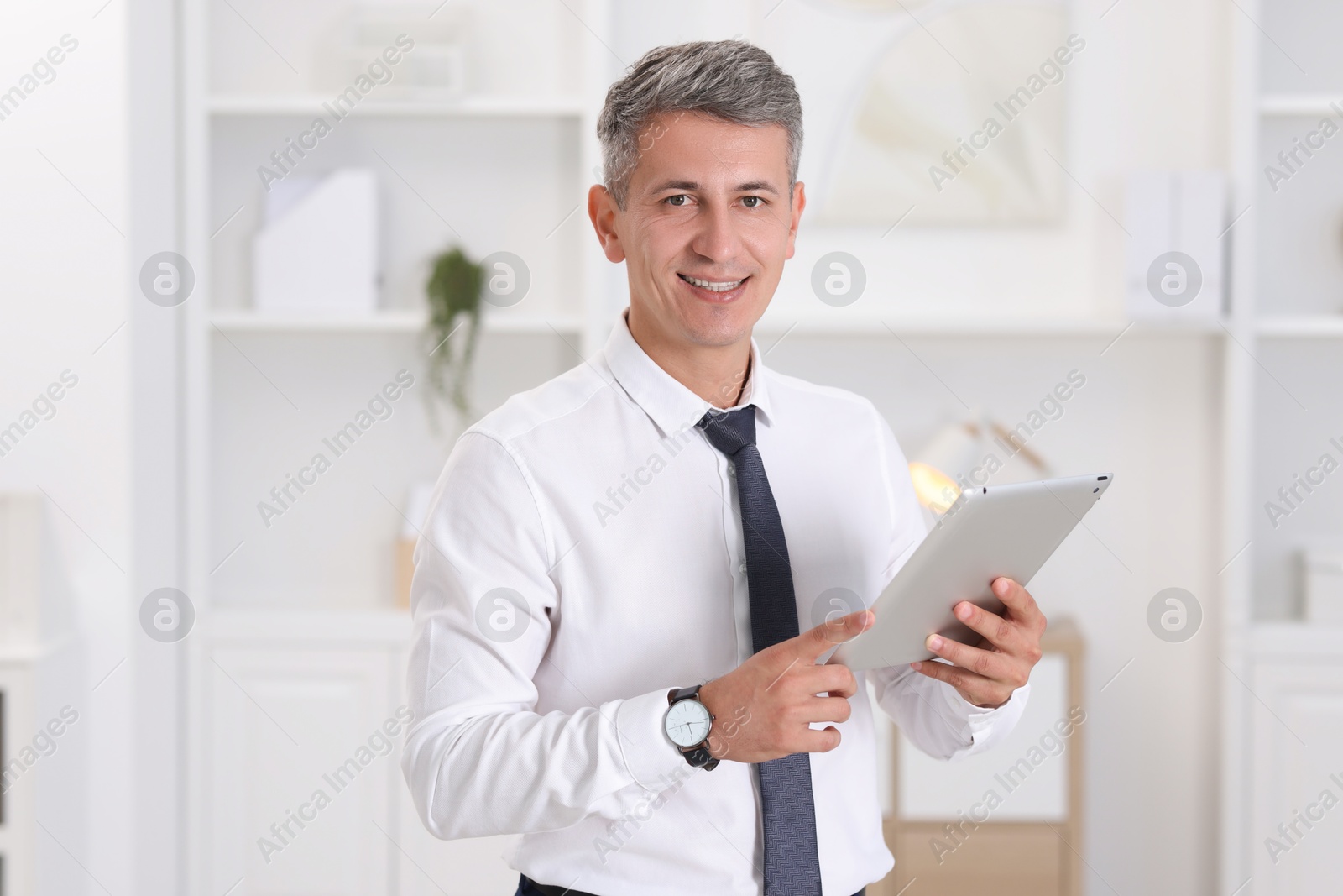 Photo of Portrait of businessman using tablet in office