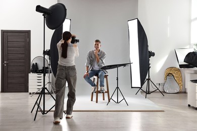 Photo of Photographer working with model in professional photo studio