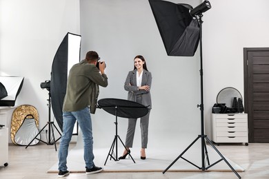 Photographer working with model in professional photo studio