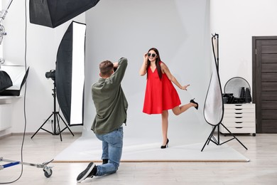 Photographer working with model in professional photo studio