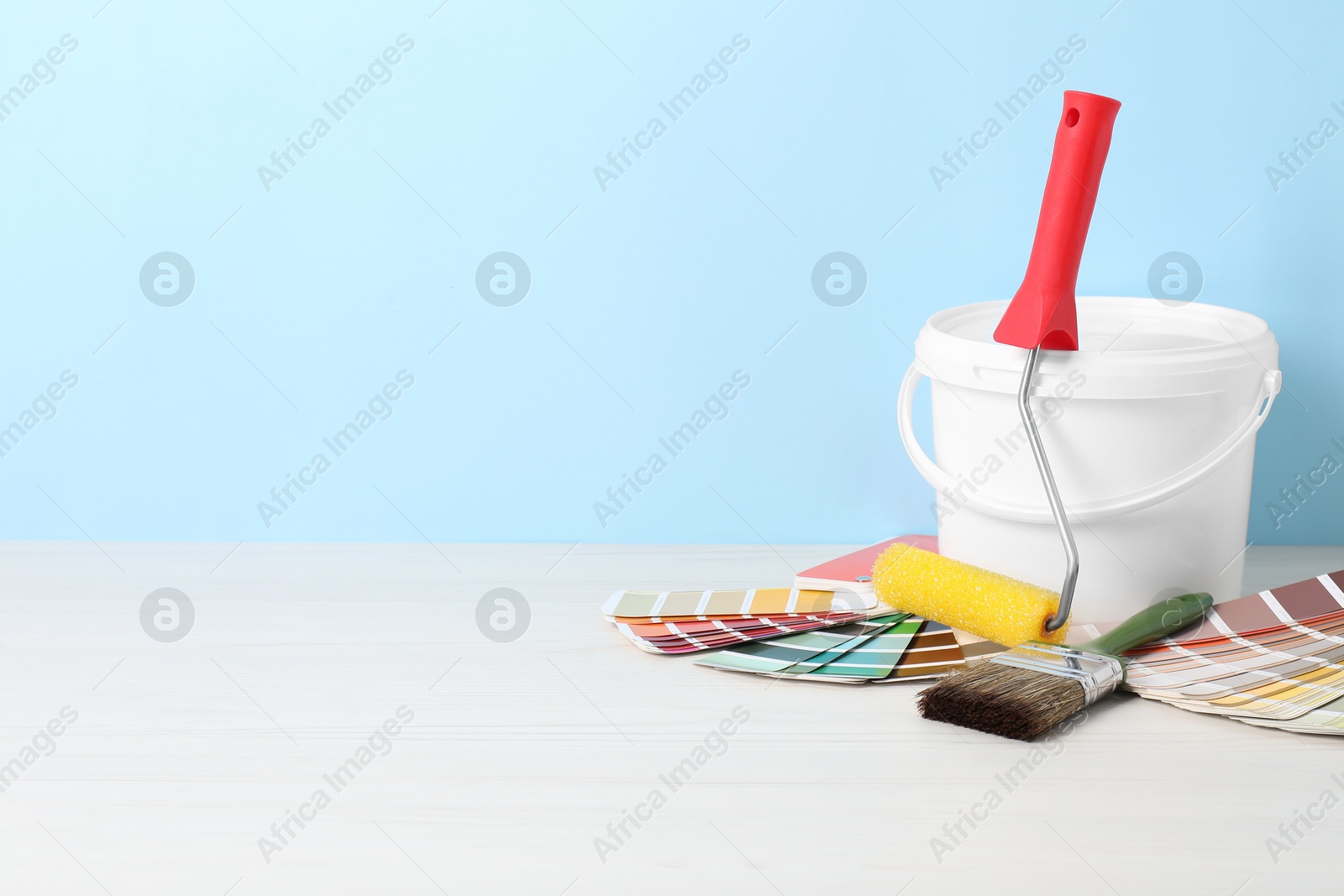 Photo of Different painter's tools on white wooden table, space for text. Decorating and design