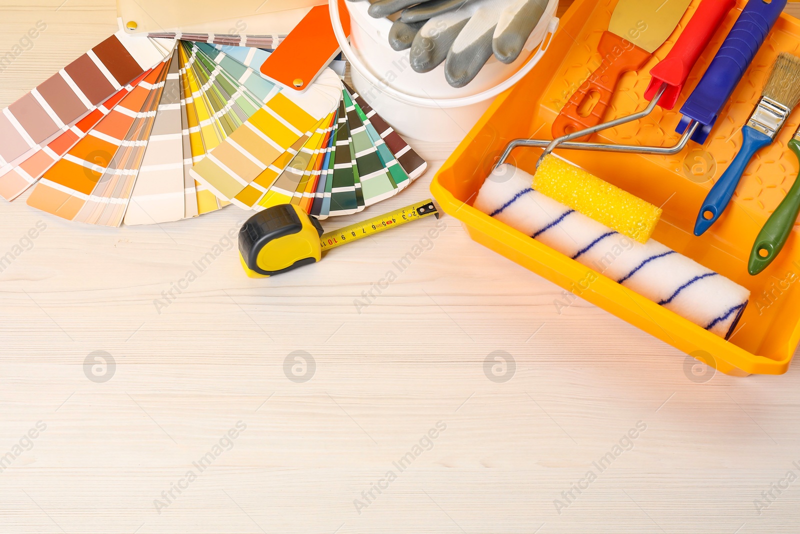 Photo of Decorating and design. Different painter's tools on white wooden table, flat lay. Space for text