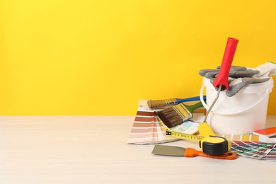 Photo of Different painter's tools on white wooden table, space for text. Decorating and design