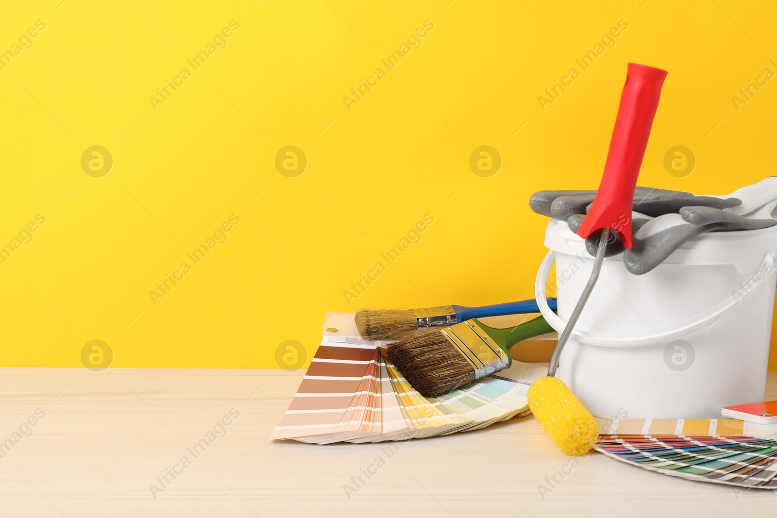 Photo of Different painter's tools on white wooden table, space for text. Decorating and design