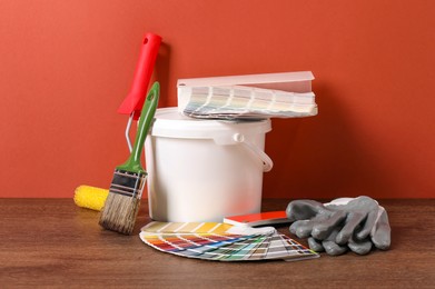 Photo of Different painter's tools on wooden table. Decorating and design