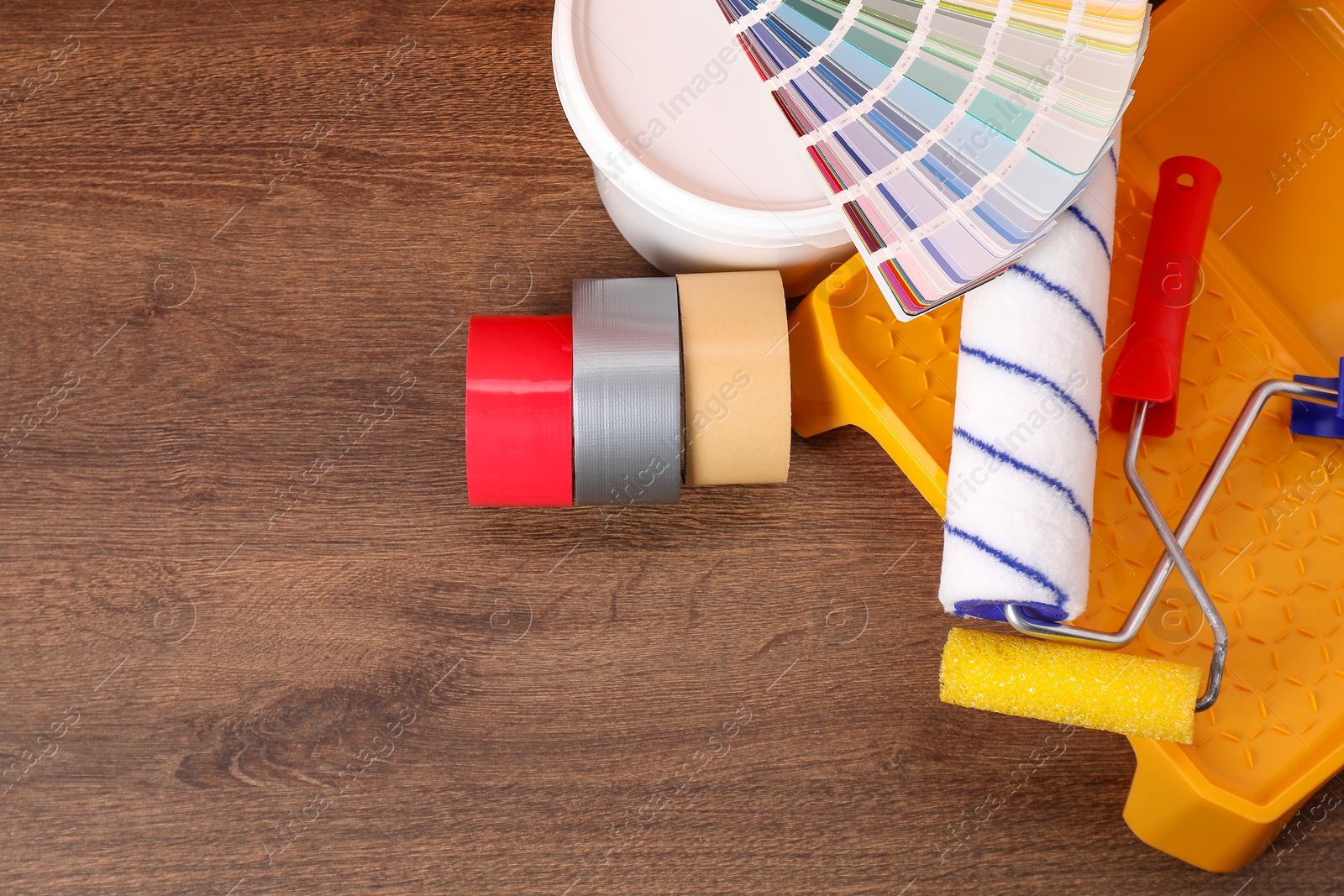 Photo of Decorating and design. Different painter's tools on wooden table, above view. Space for text