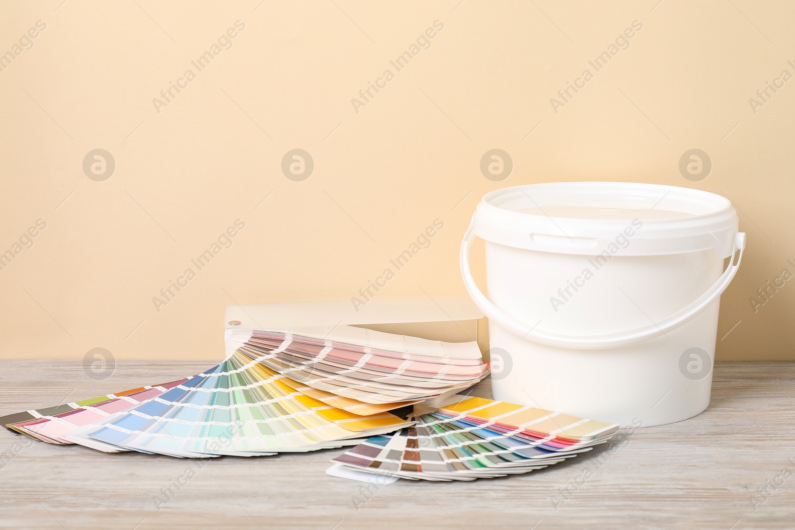 Photo of Different painter's tools on light wooden table. Decorating and design