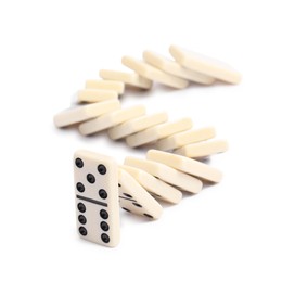 Photo of Domino effect. Tiles falling on white background