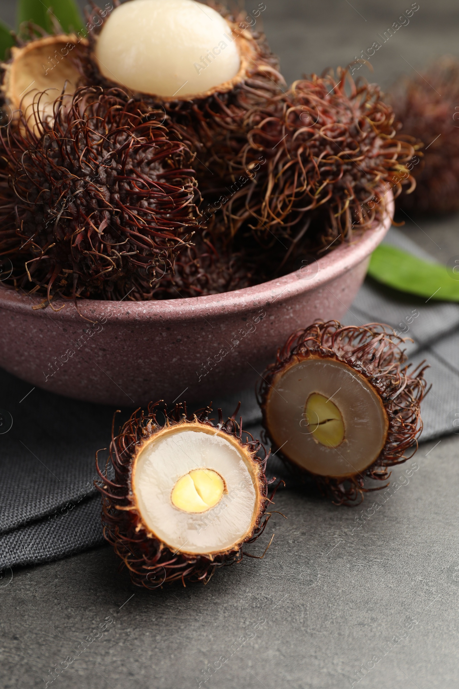 Photo of Delicious ripe rambutans on grey table, closeup