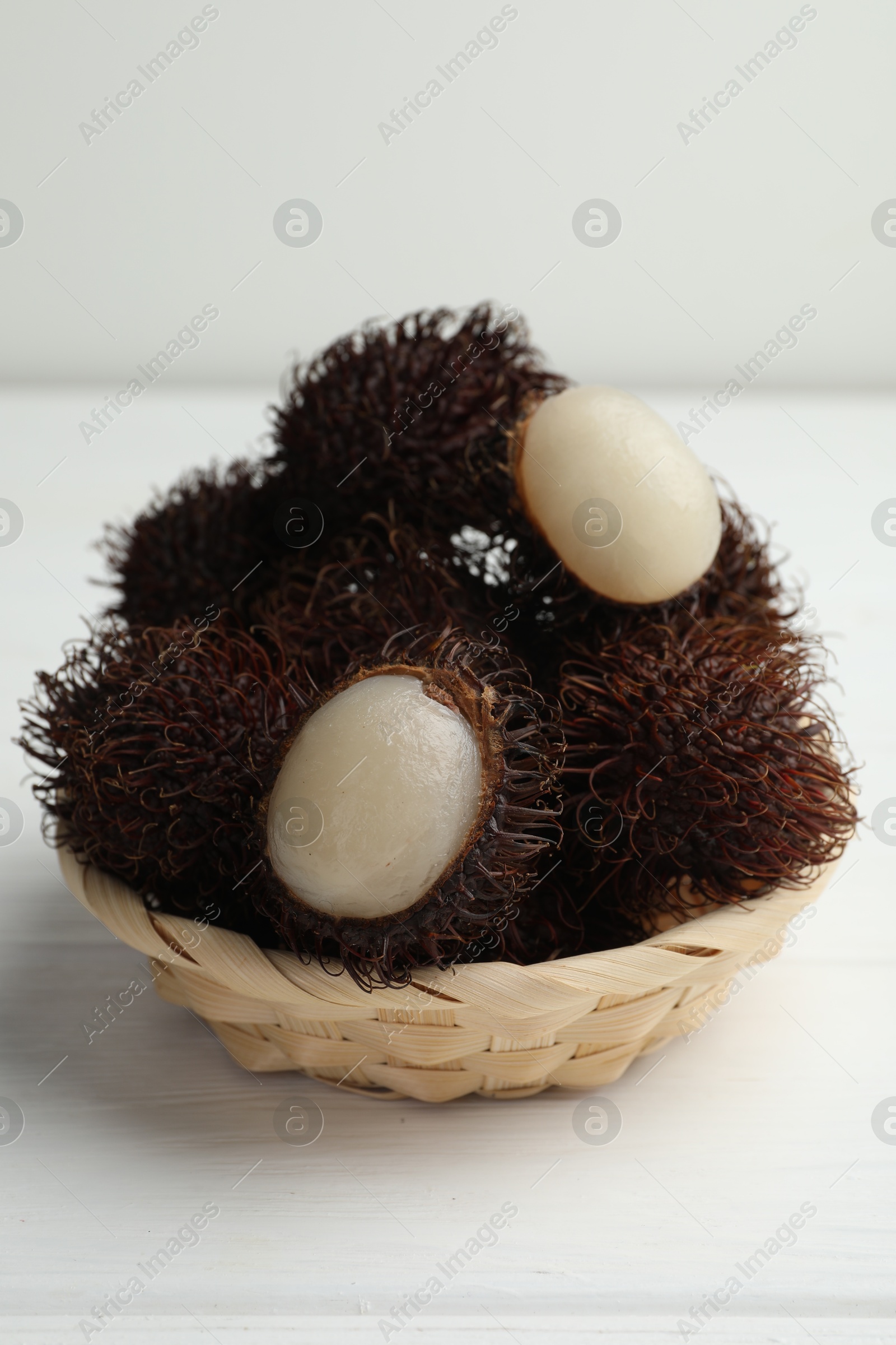 Photo of Delicious ripe rambutans on white wooden table, closeup