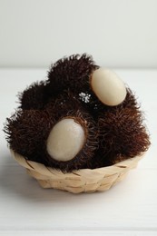 Photo of Delicious ripe rambutans on white wooden table, closeup