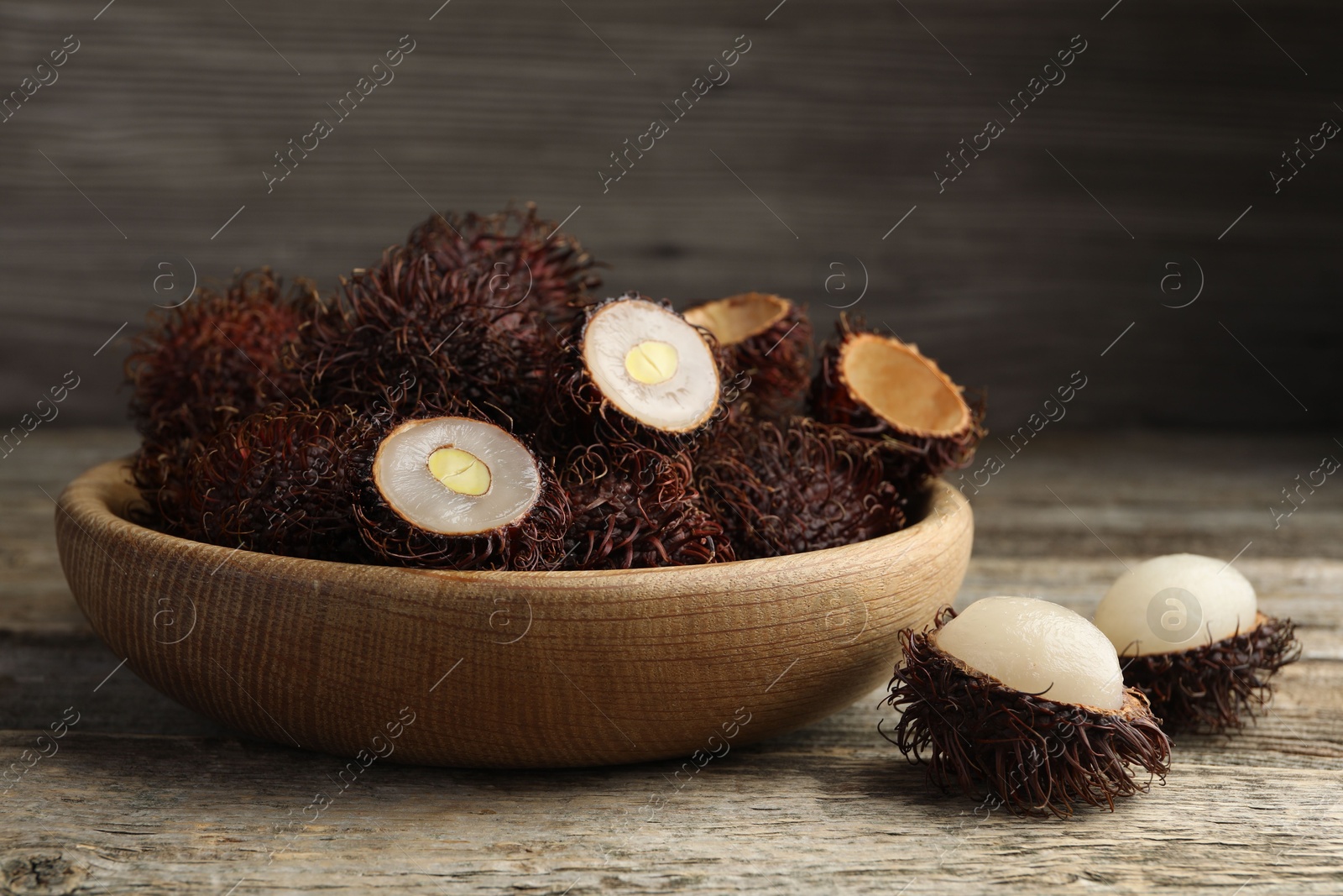 Photo of Delicious ripe rambutans on wooden table, closeup