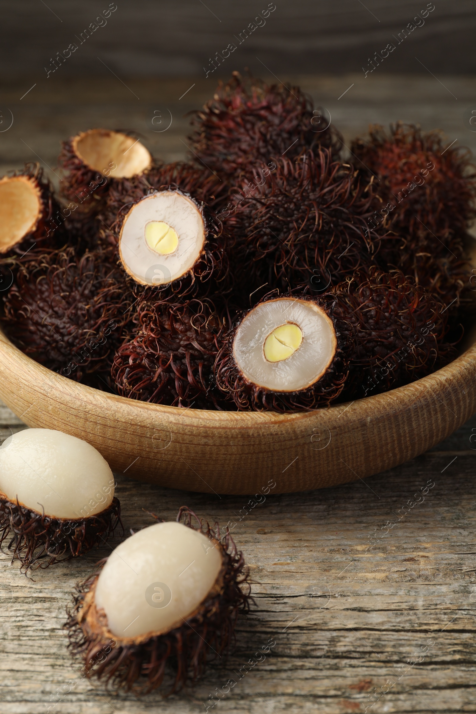 Photo of Delicious ripe rambutans on wooden table, closeup