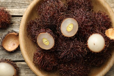 Photo of Delicious ripe rambutans on wooden table, top view