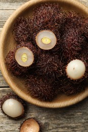 Photo of Delicious ripe rambutans on wooden table, top view