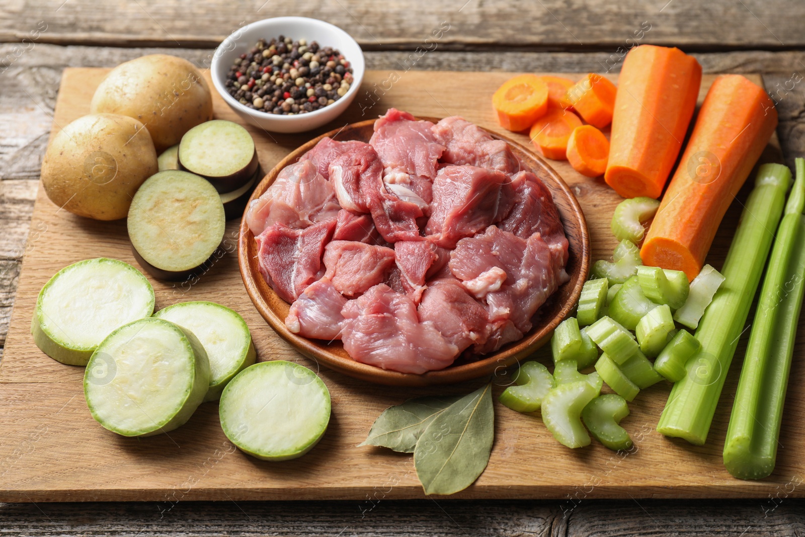 Photo of Cooking stew. Uncooked meat and vegetables on wooden table