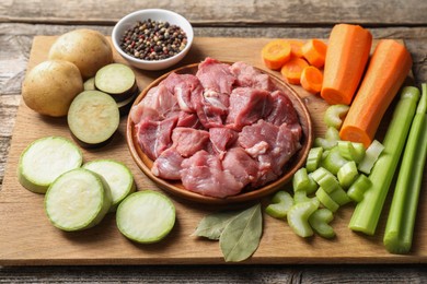 Photo of Cooking stew. Uncooked meat and vegetables on wooden table