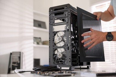 Photo of Man assembling new computer at white table, closeup