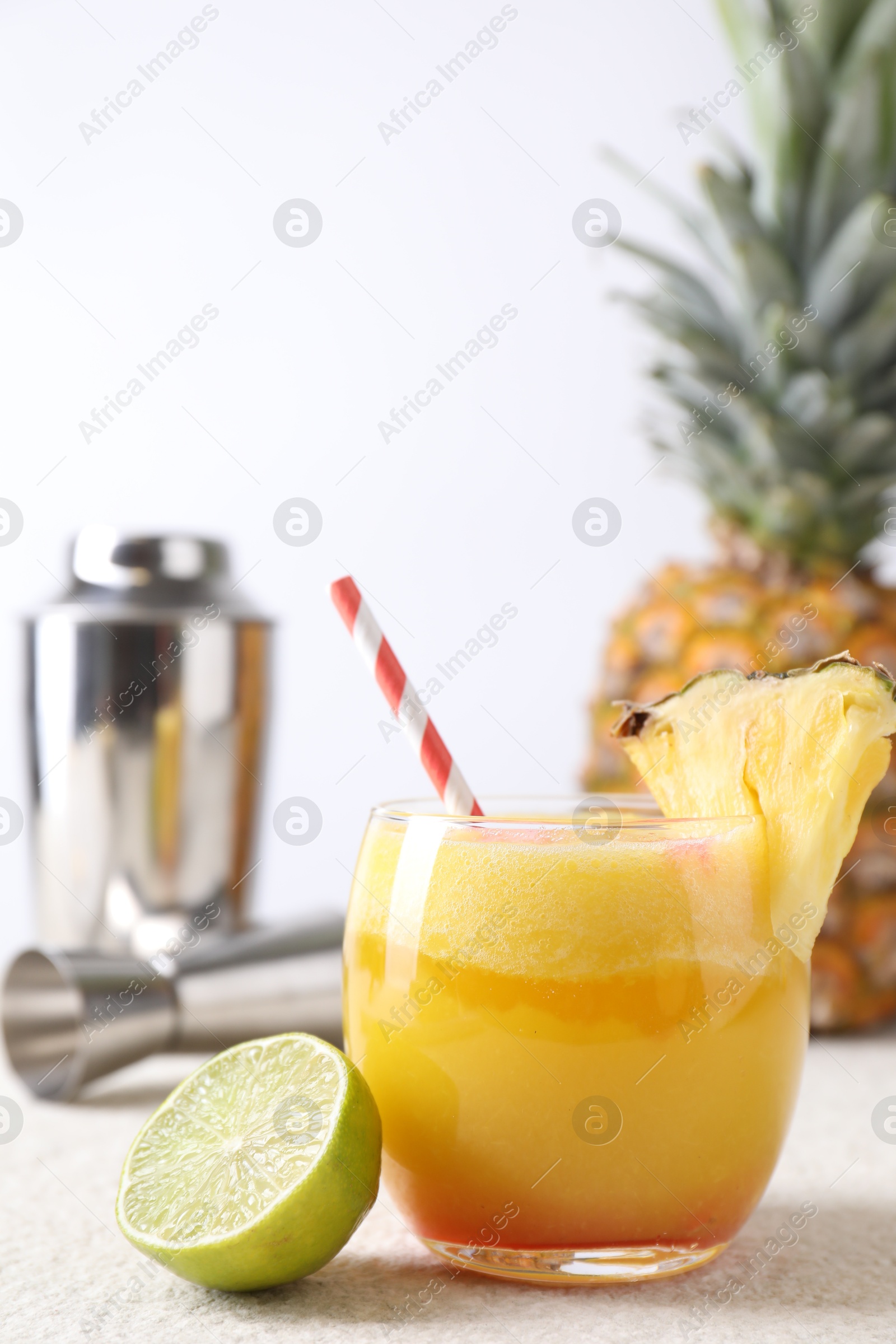 Photo of Tasty pineapple cocktail in glass served on white table