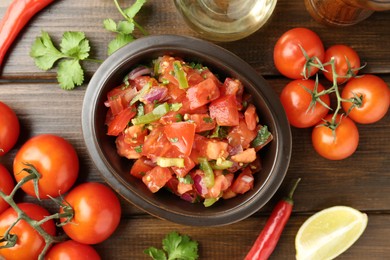 Photo of Delicious spicy salsa with ingredients on wooden table, flat lay