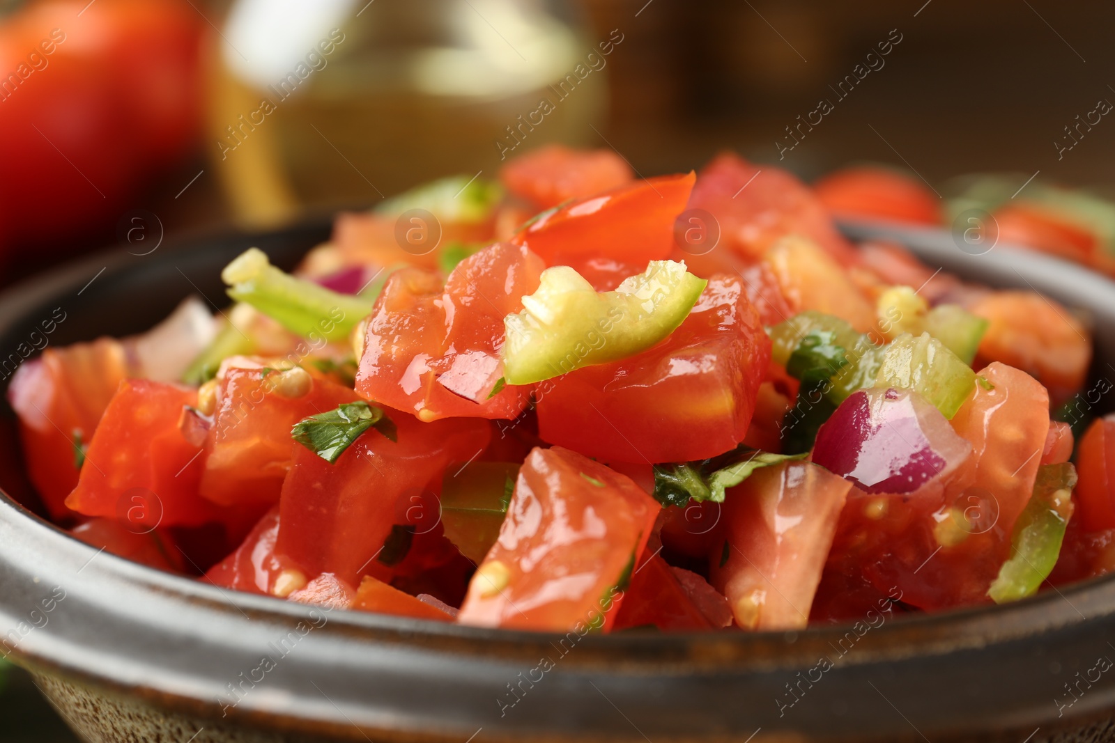 Photo of Delicious spicy salsa with herbs in bowl, closeup