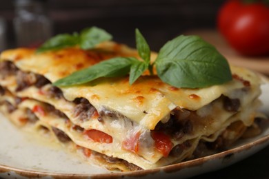 Photo of Delicious cooked lasagna with basil on plate, closeup