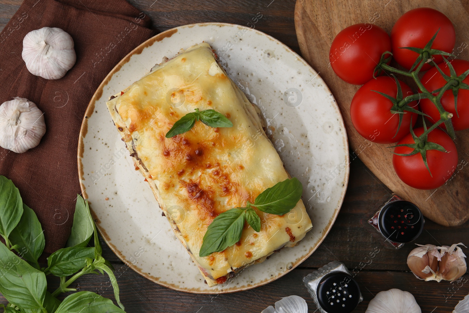 Photo of Delicious cooked lasagna and ingredients on wooden table, flat lay