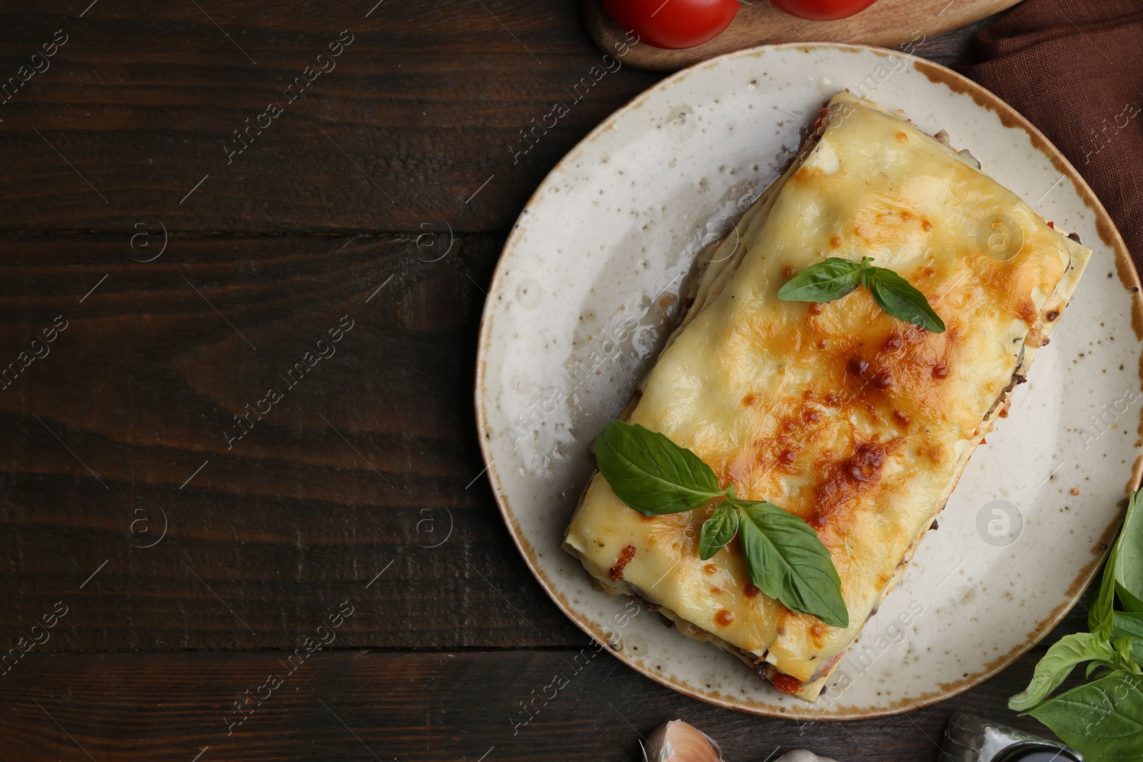 Photo of Delicious cooked lasagna with basil on wooden table, flat lay. Space for text