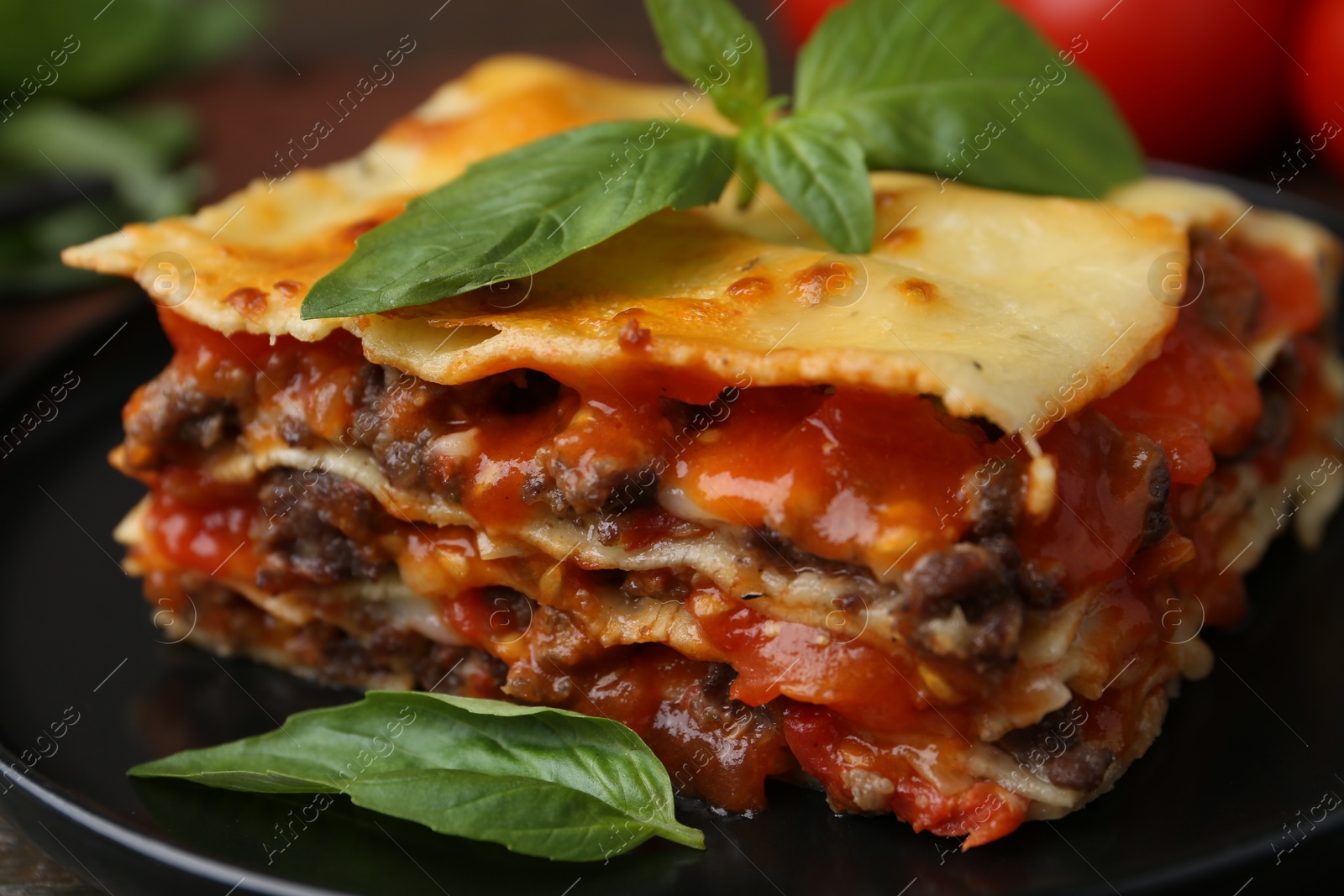 Photo of Delicious cooked lasagna with basil on plate, closeup