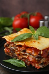 Photo of Delicious cooked lasagna with basil on wooden table, closeup