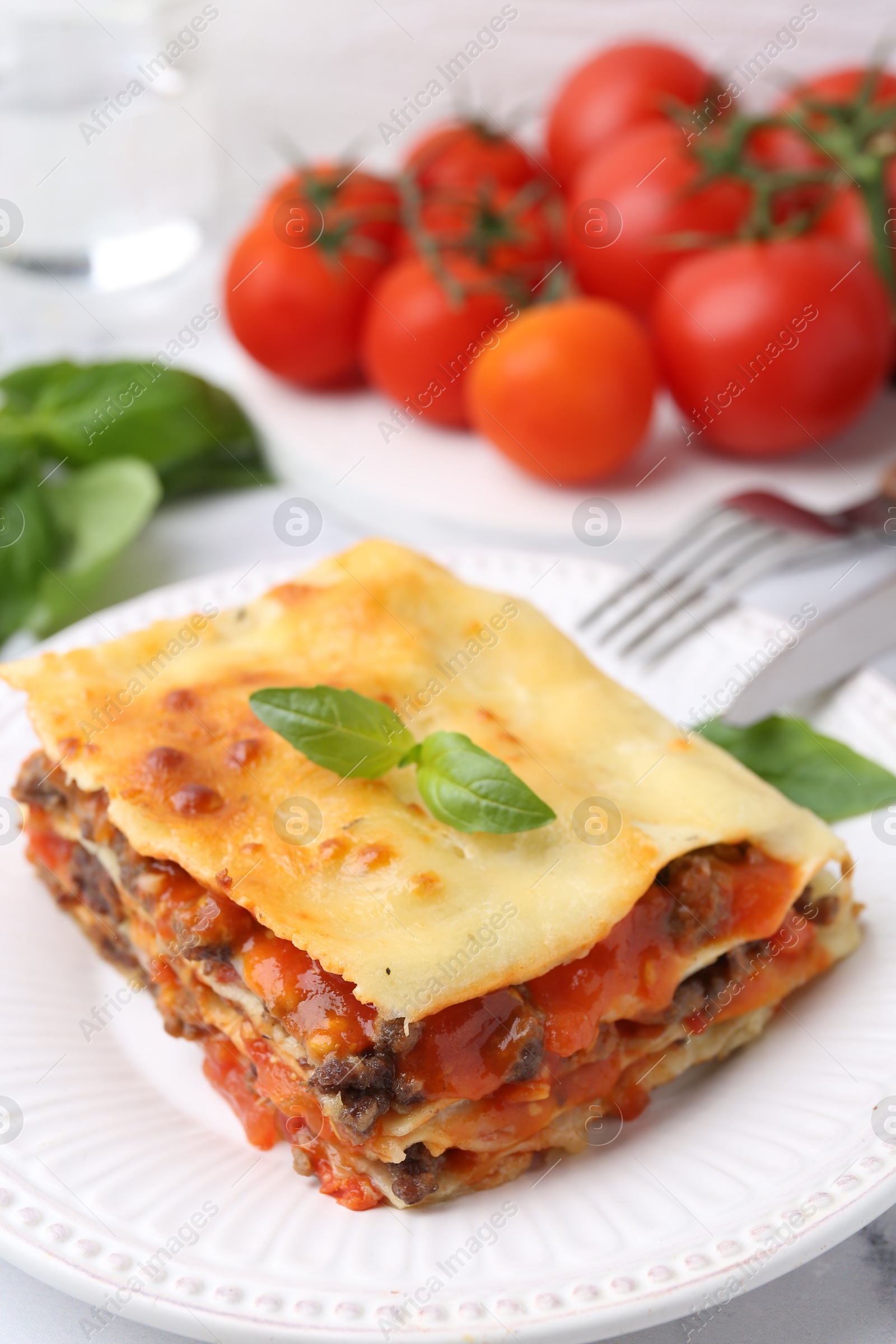 Photo of Delicious cooked lasagna with basil on table, closeup