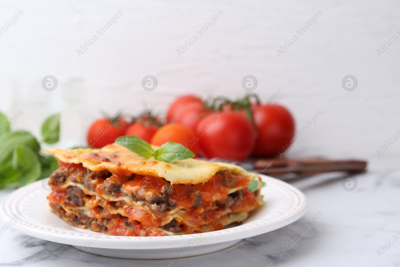 Photo of Delicious cooked lasagna on white marble table, closeup