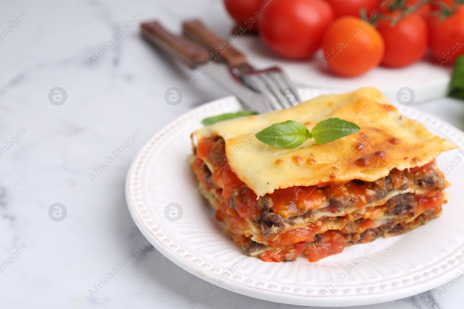 Photo of Delicious cooked lasagna on white marble table, closeup