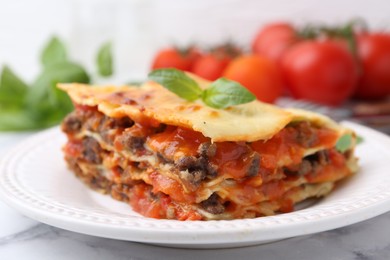 Photo of Delicious cooked lasagna on white marble table, closeup