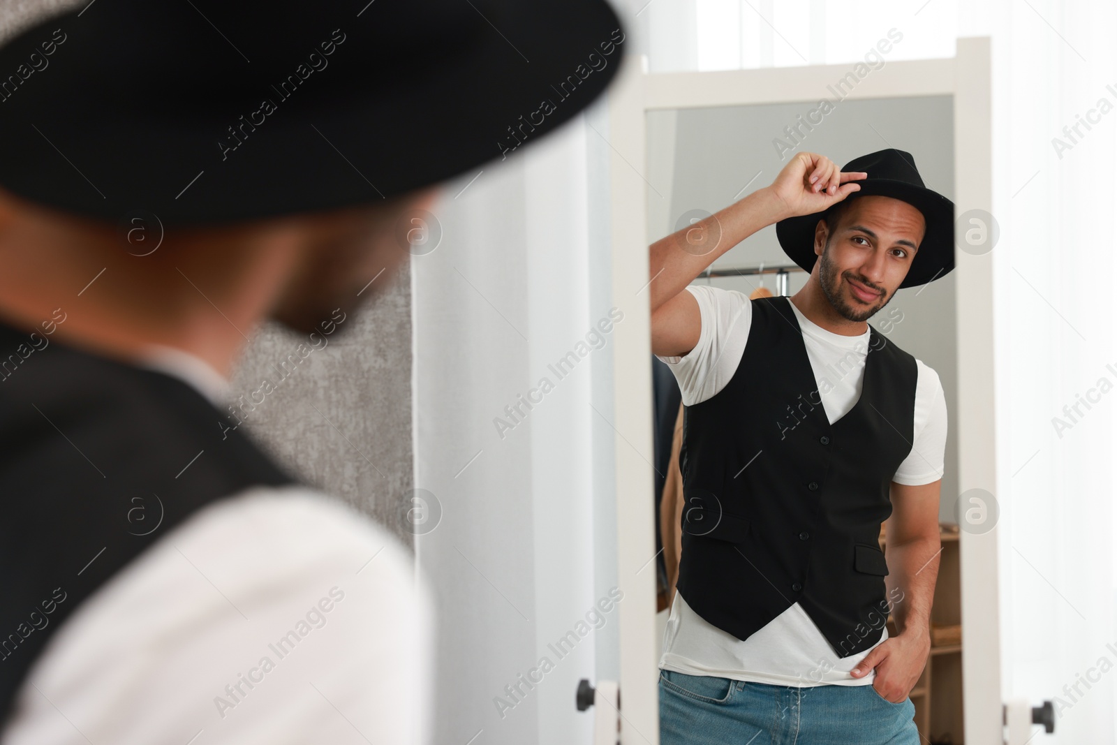 Photo of Handsome man looking at mirror at home