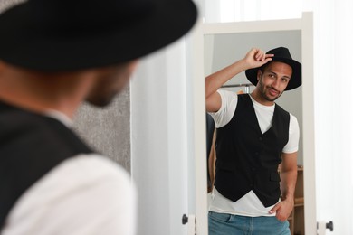 Photo of Handsome man looking at mirror at home