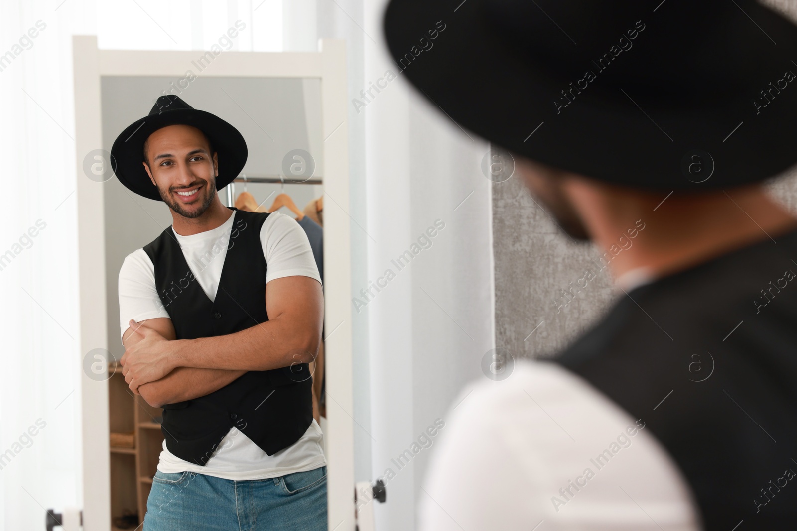 Photo of Smiling man looking at mirror at home