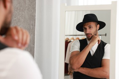 Handsome man looking at mirror at home