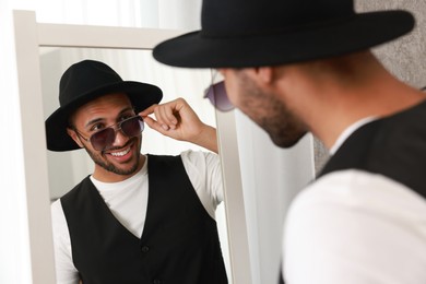 Photo of Smiling man looking at mirror at home