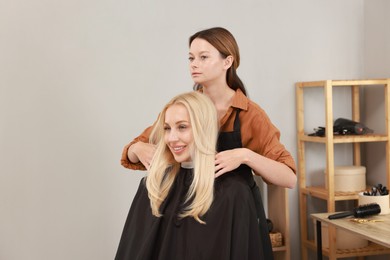 Photo of Hair cutting. Professional hairdresser working with client in salon