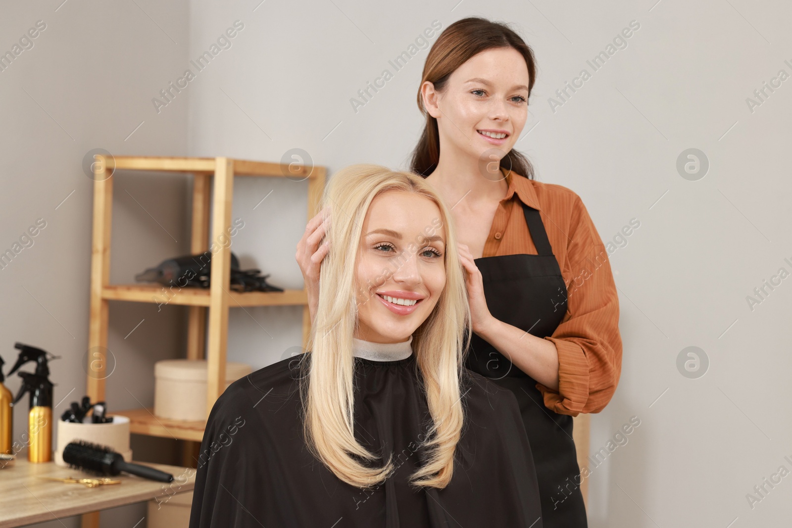 Photo of Hair cutting. Professional hairdresser working with client in salon