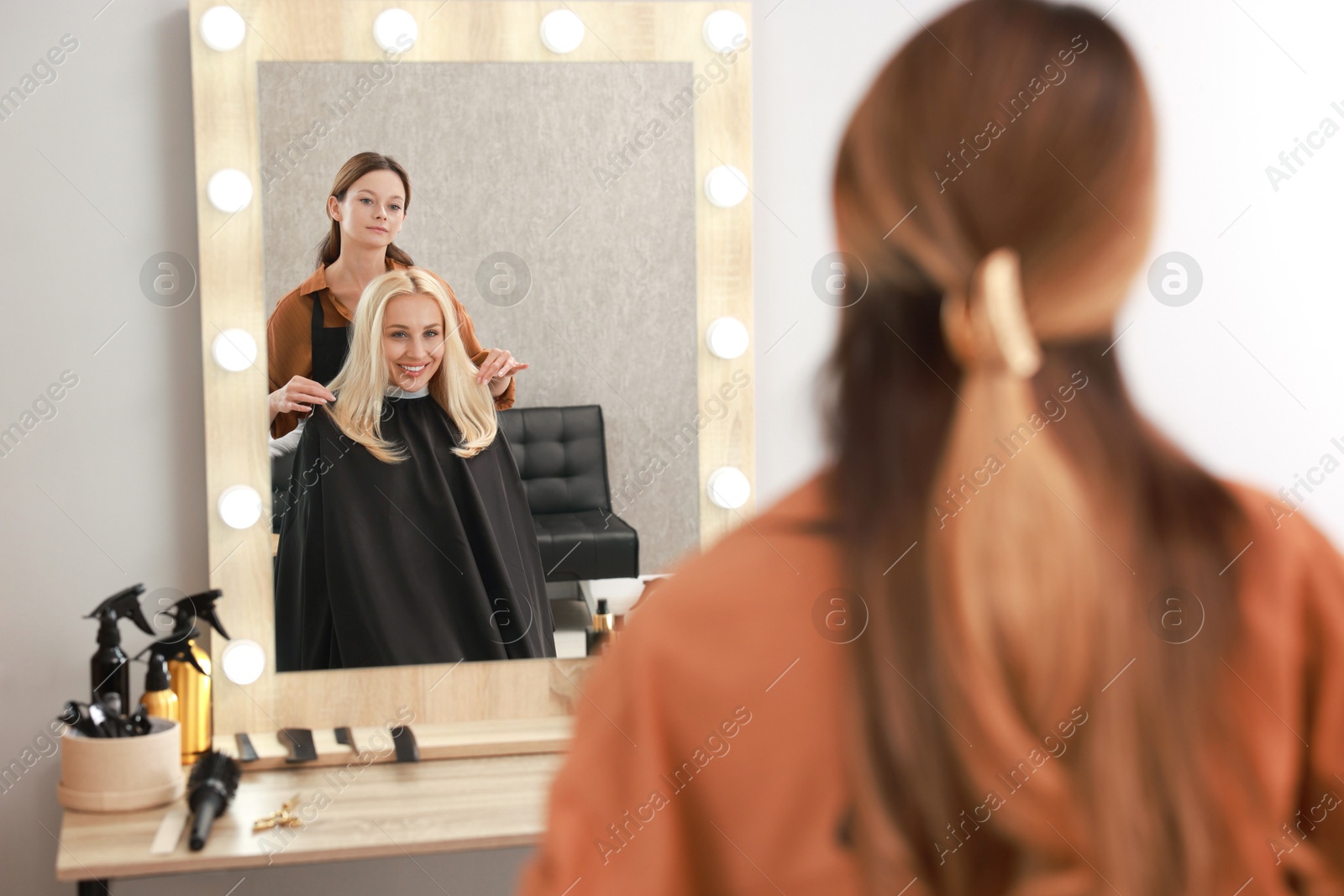 Photo of Hair cutting. Professional hairdresser working with client in salon, selective focus