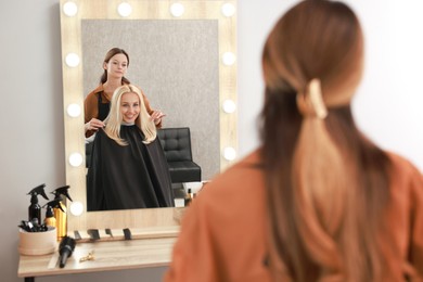 Photo of Hair cutting. Professional hairdresser working with client in salon, selective focus