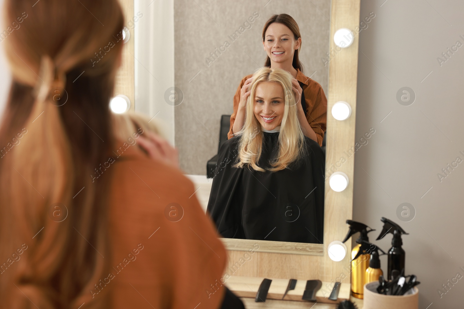 Photo of Hair cutting. Professional hairdresser working with client in salon, selective focus