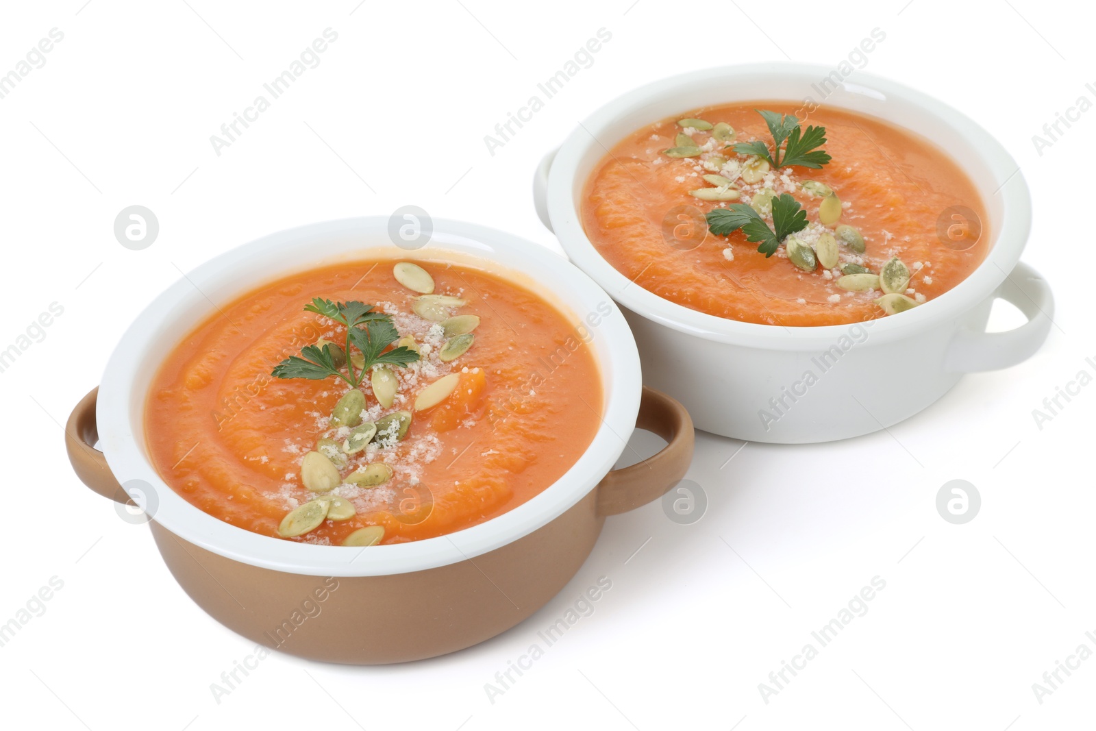 Photo of Delicious sweet potato soup with pumpkin seeds and parsley in bowls isolated on white