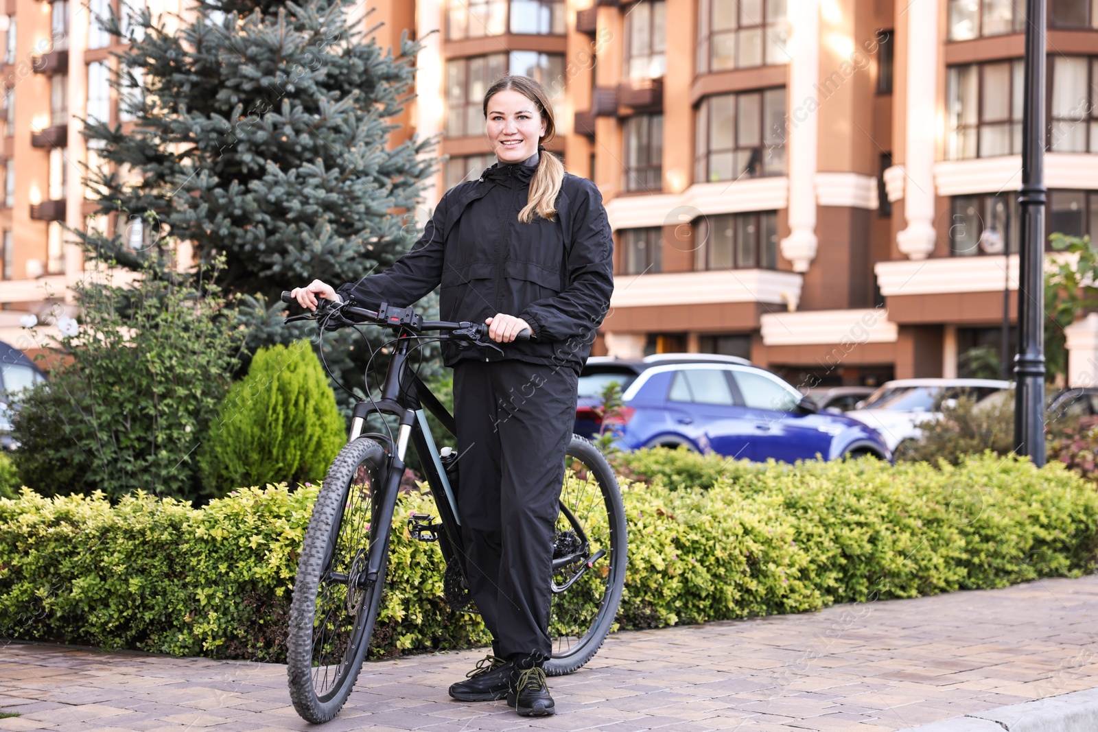 Photo of Smiling woman with bicycle outdoors. Healthy lifestyle