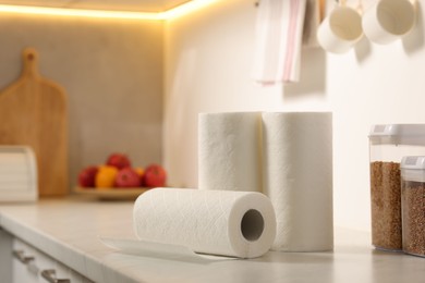 Photo of Rolls of paper towels on white marble countertop in kitchen