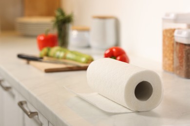 Photo of Roll of paper towels on white marble countertop in kitchen, closeup. Space for text