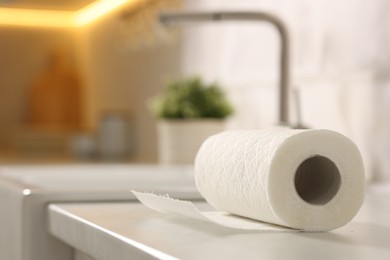 Photo of Roll of paper towels on white countertop in kitchen, closeup. Space for text