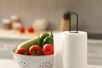 Photo of Roll of paper towels and vegetables in kitchen, closeup